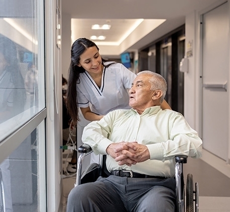 nurse helping a senior man in a wheelchair